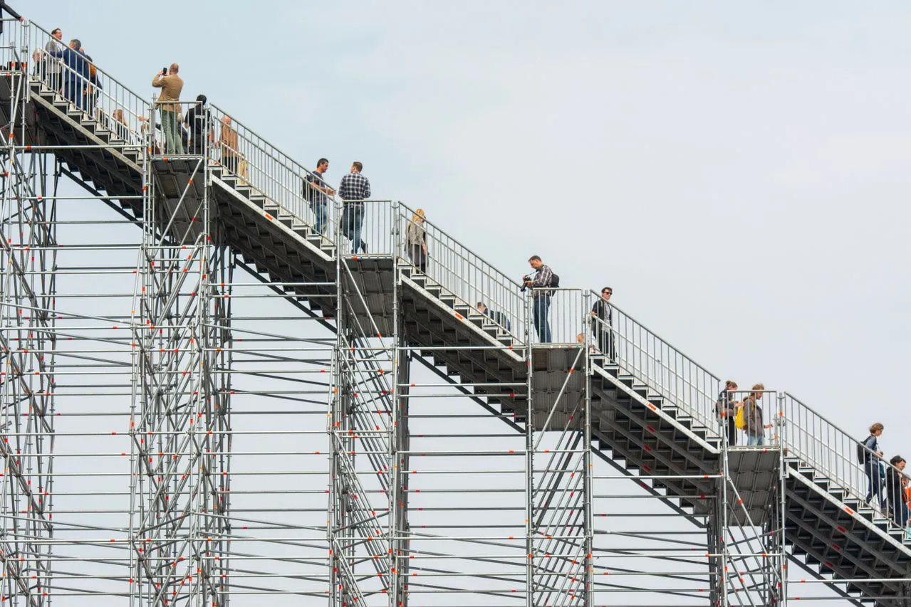 People crossing a steel access stairway high above the ground