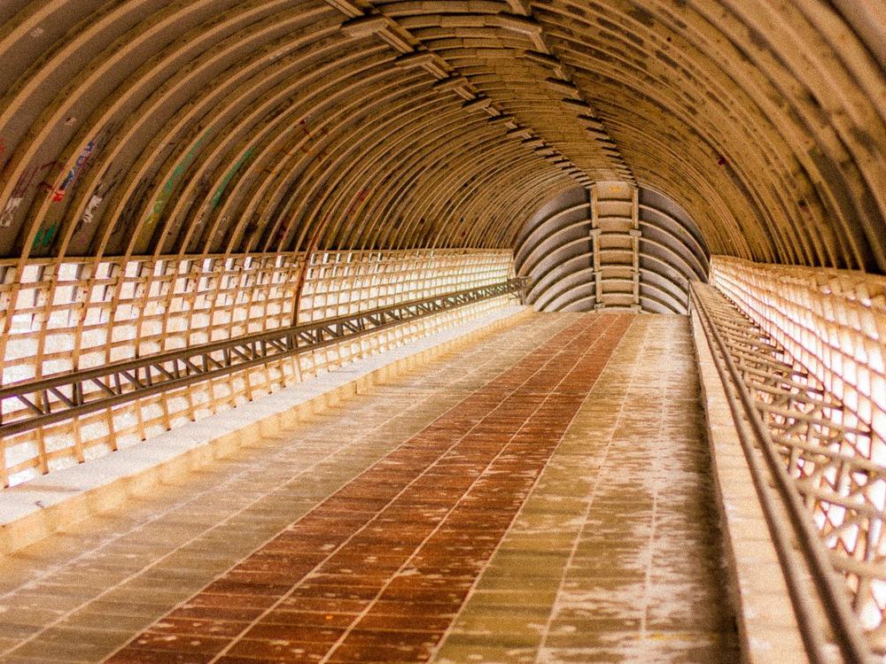 The ribbed concrete lining of a finished tunnel, lit along its length
