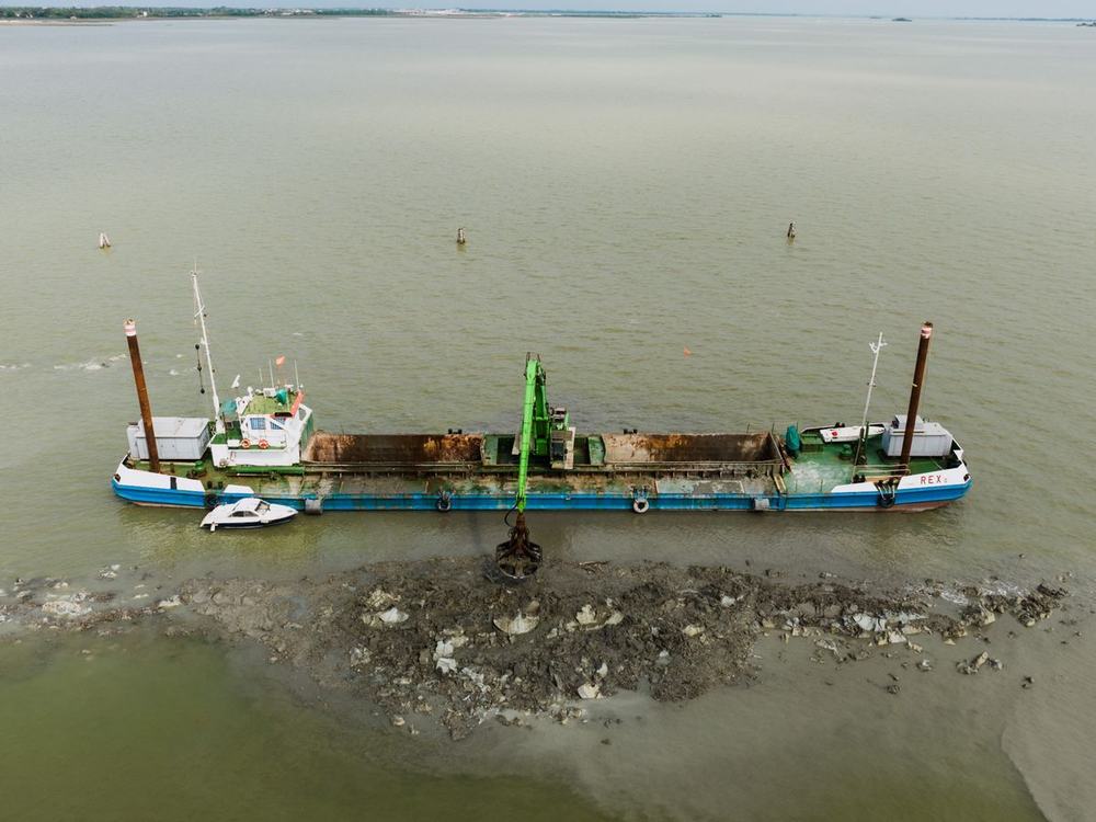 A dredger working in shallow coastal water