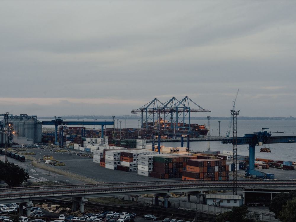 Quay cranes and stacked containers along a working dockside