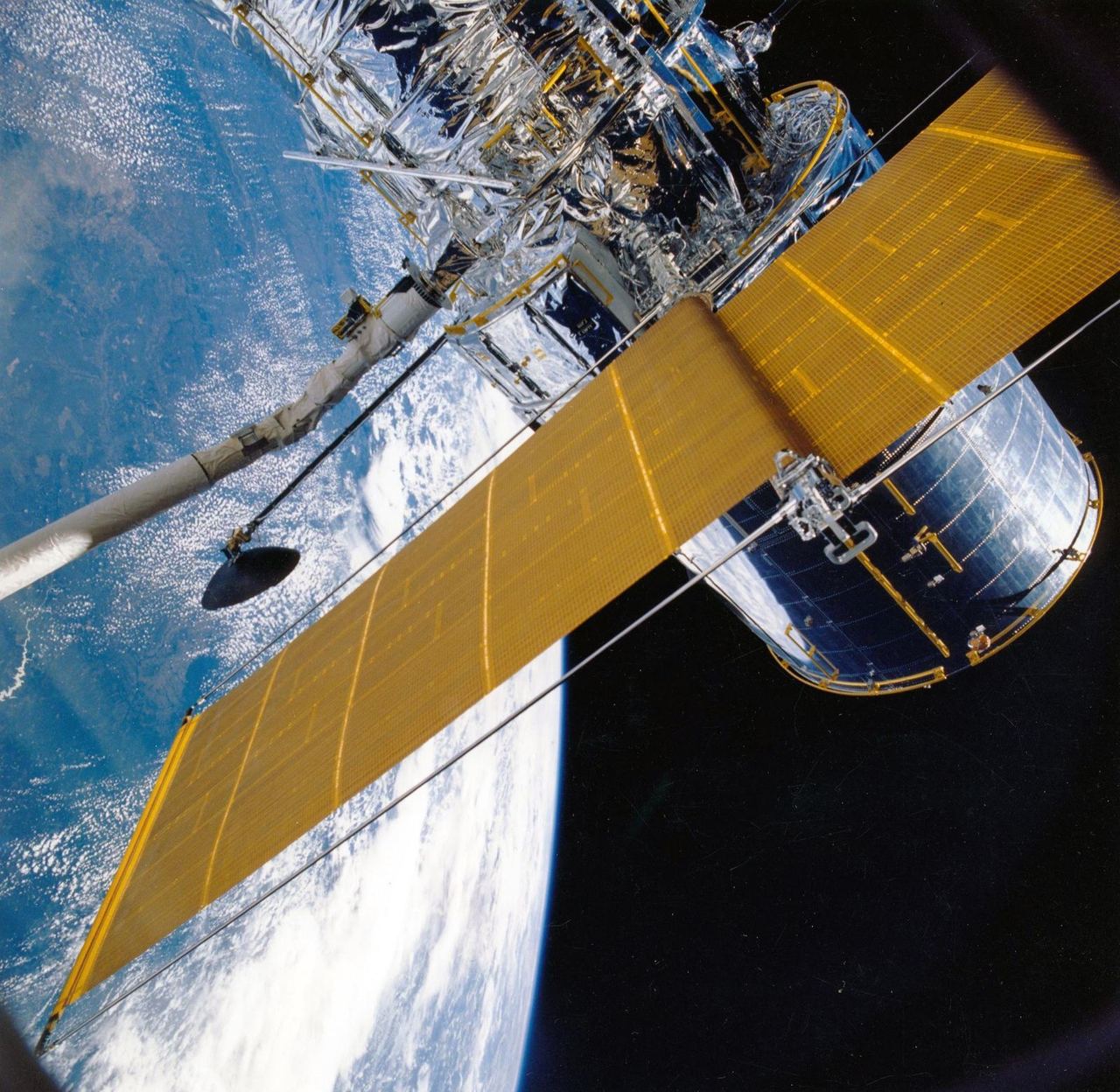 A satellite in orbit, solar panels extended, with the Earth below