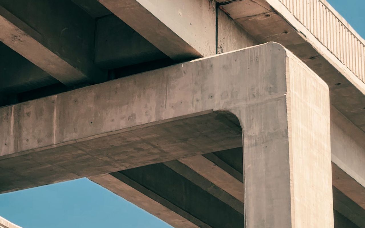 The underside of a concrete road viaduct, its beams meeting the pier head