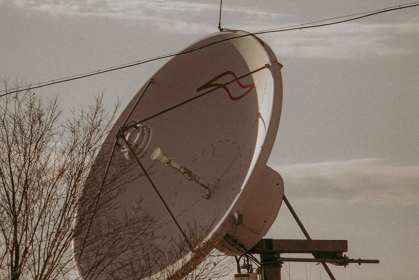 A satellite dish silhouetted against a late afternoon sky