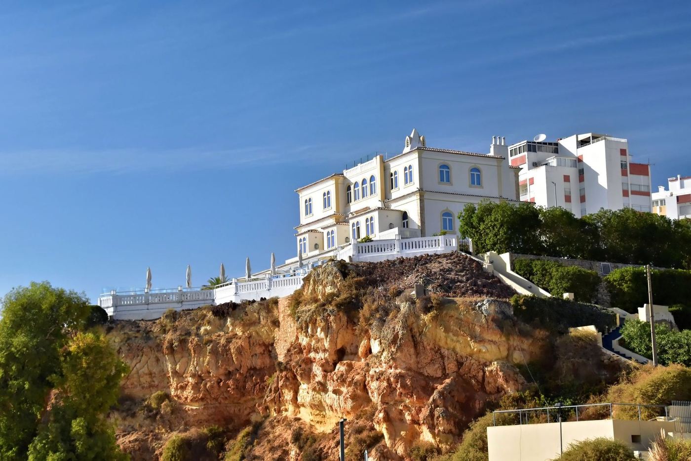A house standing at the edge of an eroding cliff above the sea